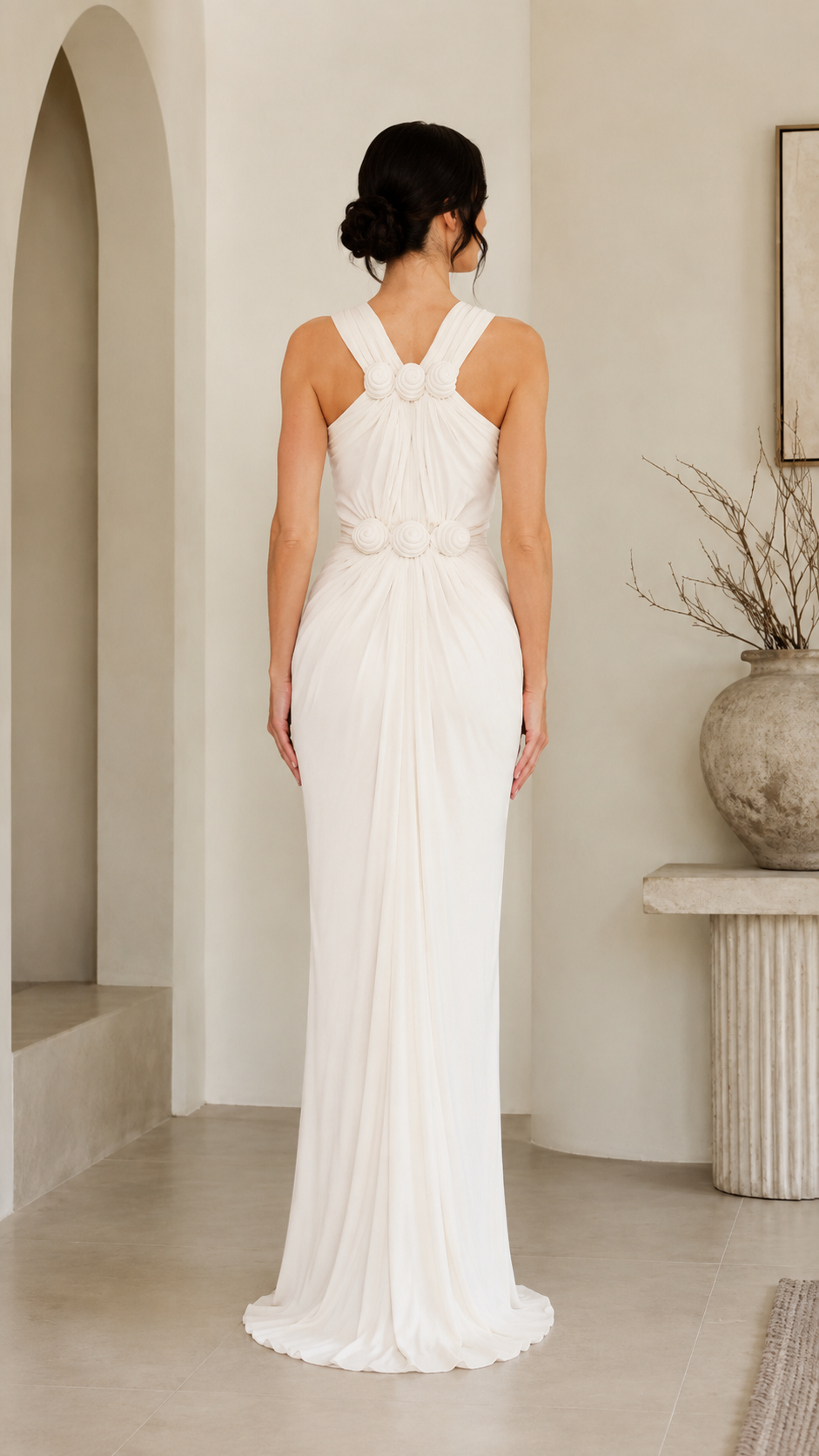 Back view of ivory rosette halter ruched maxi gown with crossed straps