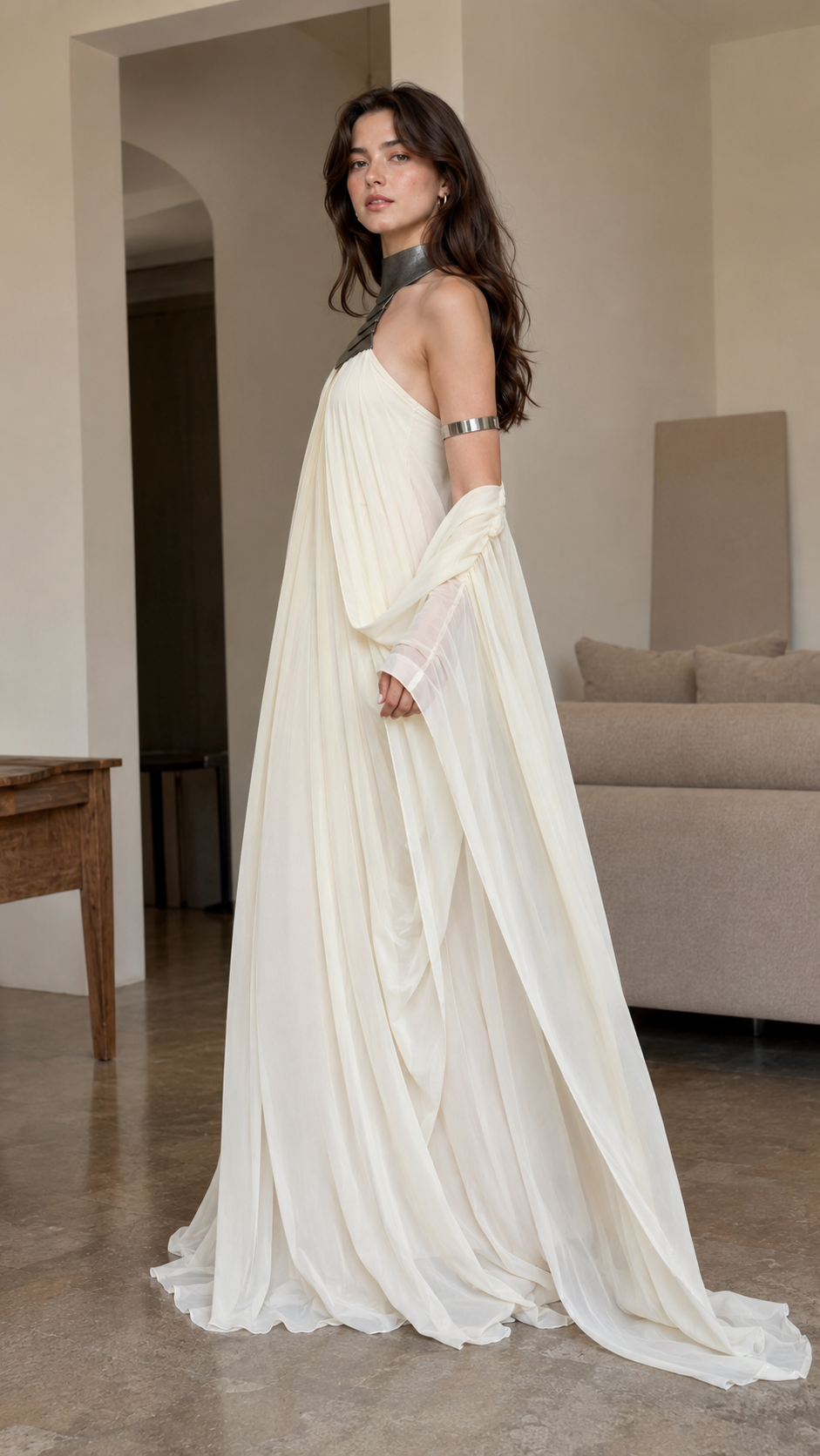Side view of ivory flowing halter maxi gown with cape-style drape