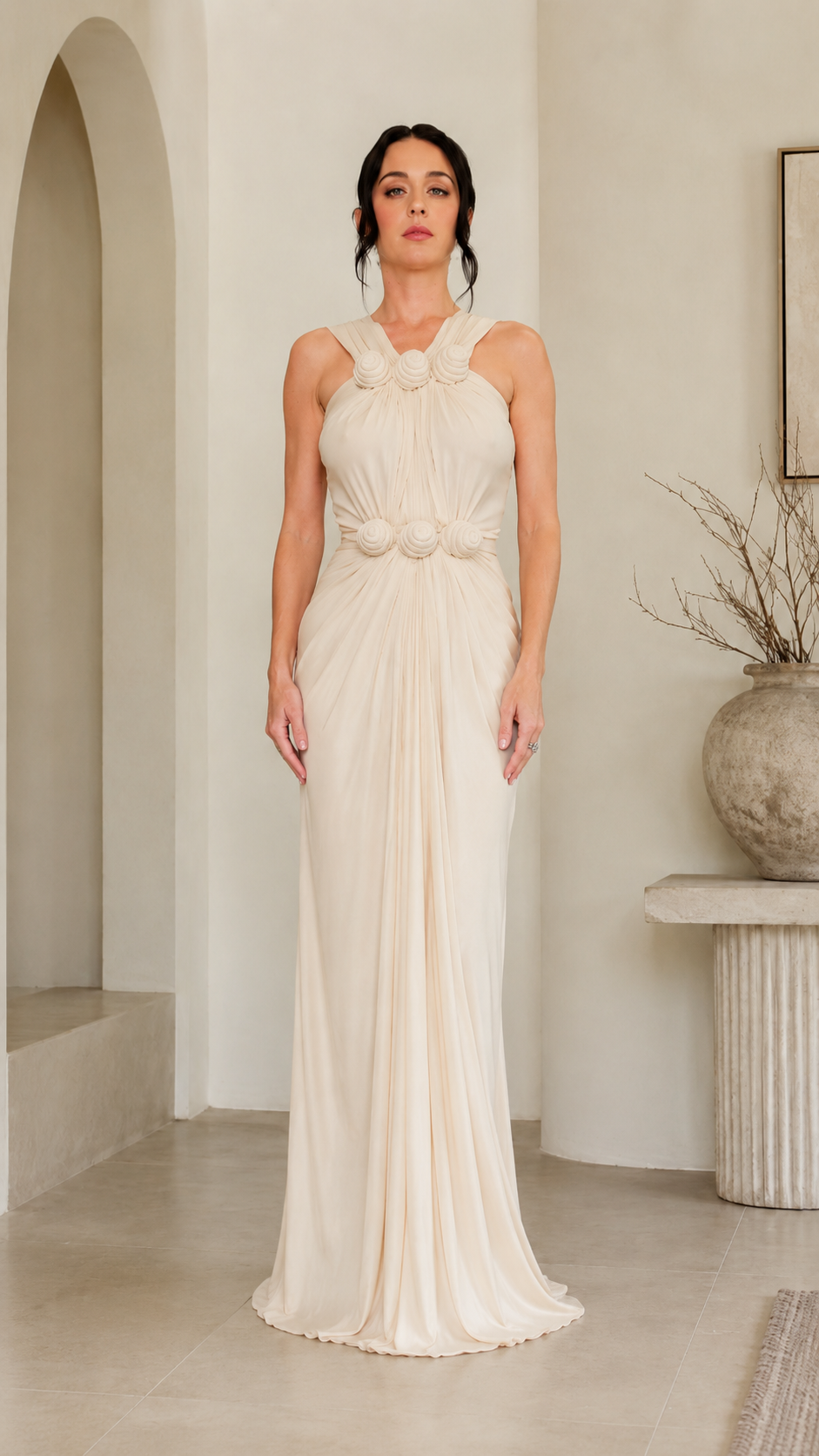 Front view of ivory rosette halter maxi gown with gathered drape
