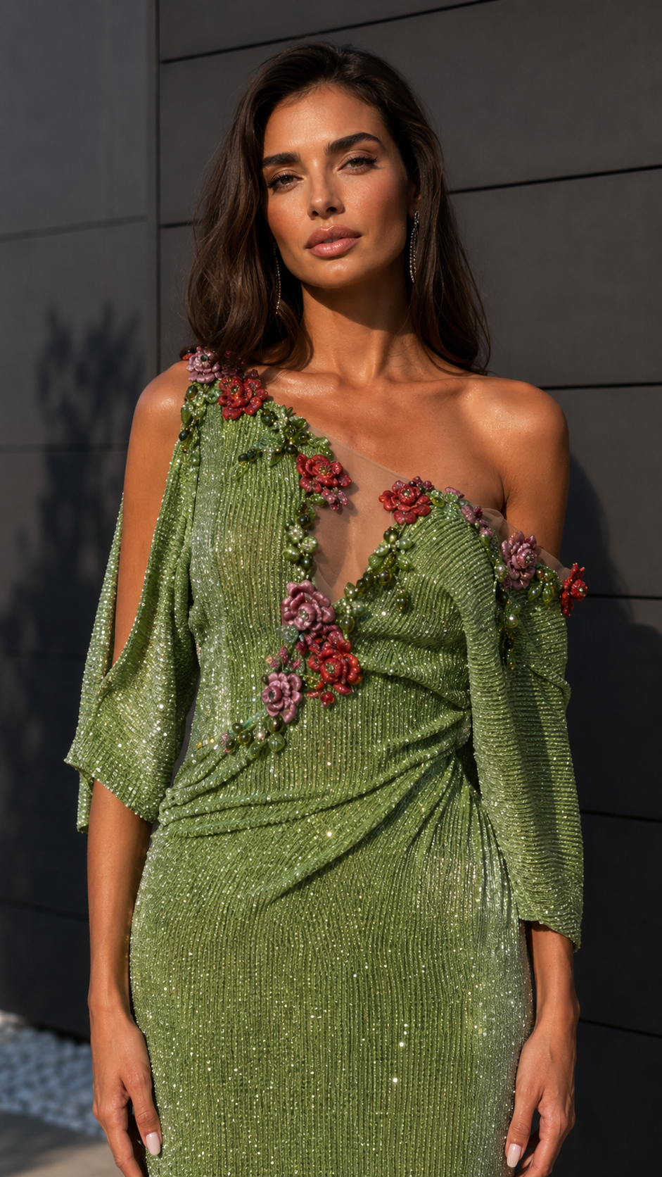 Close-up of sage green gown bodice showing floral appliqué, one-shoulder neckline, and shimmer texture