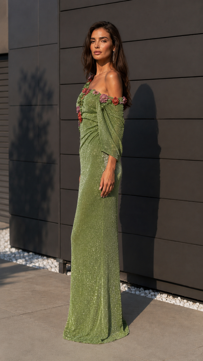 Side view of sage green one-shoulder evening gown with draped sleeve and fitted silhouette